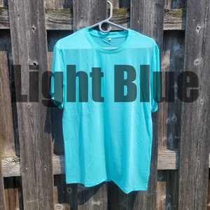 May include: A light blue t-shirt hanging on a wooden fence.