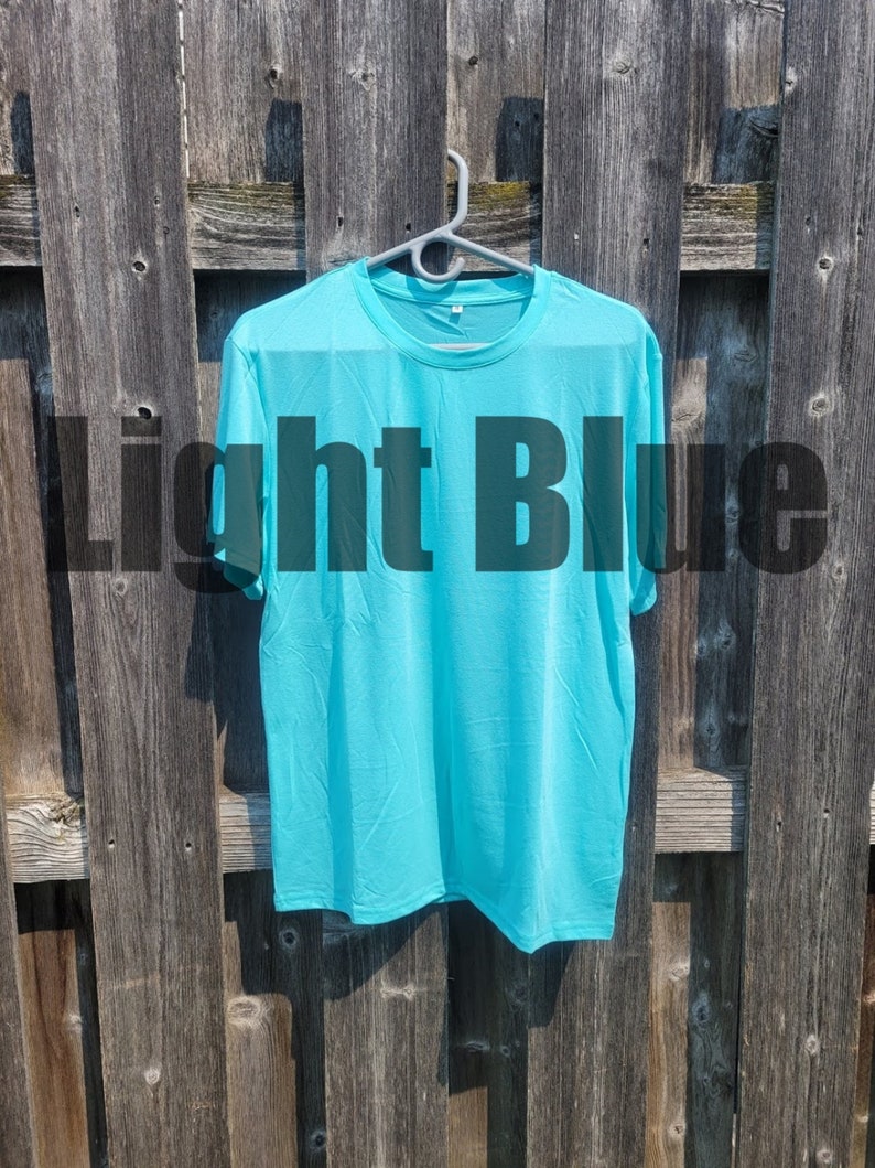 May include: A light blue t-shirt hanging on a wooden fence.