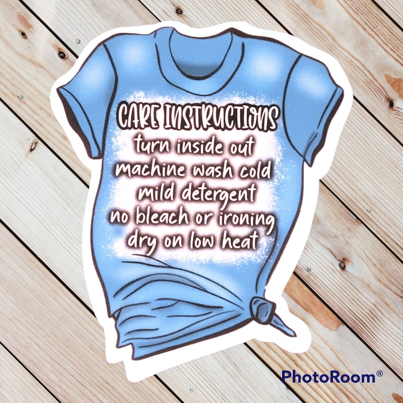 Peut inclure: Un t-shirt bleu avec du texte blanc qui dit "CARE INSTRUCTIONS turn inside out machine wash cold mild detergent no bleach or ironing dry on low heat".