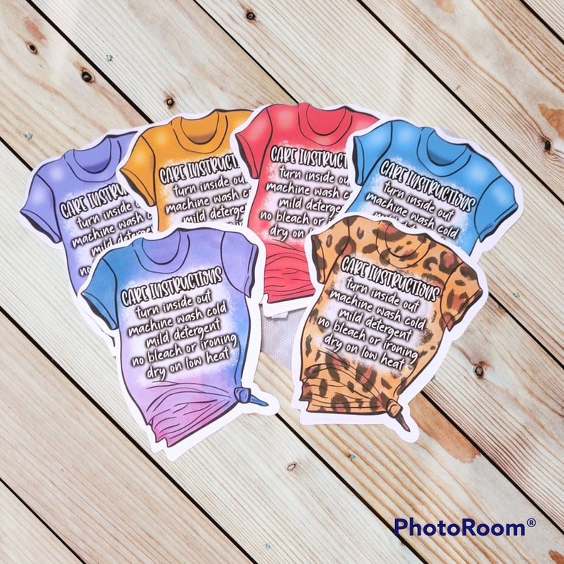 Peut inclure: Cinq &eacute;tiquettes de t-shirt thermocollantes color&eacute;es avec des instructions d'entretien. Les &eacute;tiquettes sont imprim&eacute;es sur un fond blanc avec du texte noir. Le texte indique : "Instructions d'entretien : Retourner &agrave; l'envers, laver en machine &agrave; froid, d&eacute;tergent doux, pas de javel ni de repassage, s&eacute;cher &agrave; basse temp&eacute;rature."