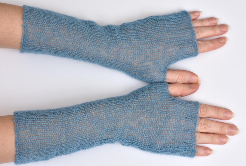 May include: A pair of blue fingerless gloves crafted from a fine, semi-sheer knit material. These arm warmers extend from the knuckles to the mid-forearm, featuring a simple thumb opening and a lightweight, airy texture with a subtle heathered appearance.