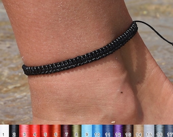 May include: A black braided ankle bracelet with a simple knot closure.