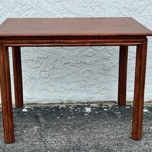 May include: A rectangular wooden side table with a rich brown finish. The table has a simple design with four straight legs and a slightly overhanging top. The table's dimensions are approximately 76 cm long, 46 cm wide, and 71 cm high.