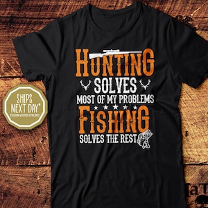 May include: Black t-shirt with the text "HUNTING SOLVES MOST OF MY PROBLEMS FISHING SOLVES THE REST" in orange and white. The design includes a rifle, antlers, stars, and a fish. The shirt is from "la Tees Shirt Company."