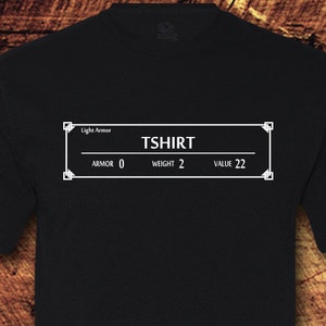 May include: Black t-shirt with a white graphic of a video game inventory screen. The screen reads "TShirt" with the stats "Armor: 0, Weight: 2, Value: 22".