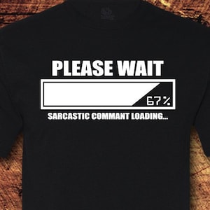 May include: Black t-shirt with a white graphic that says "PLEASE WAIT" with a progress bar that says "67%" and "SARCASTIC COMMENT LOADING..."