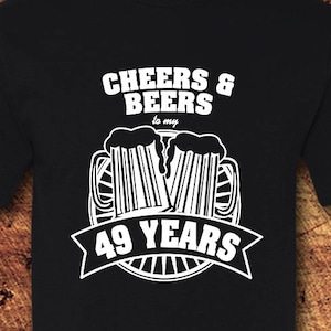 May include: Black t-shirt with white text that reads "Cheers & Beers to my 49 Years" with a graphic of two beer mugs.