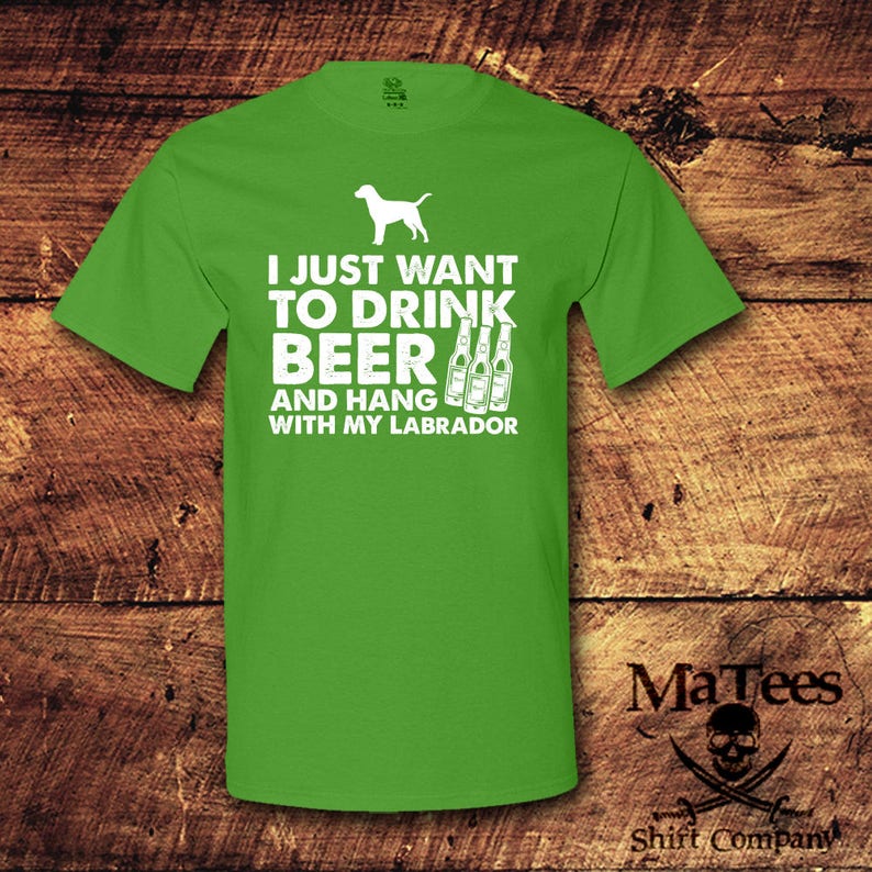 May include: Green t-shirt with white text that reads "I just want to drink beer and hang with my labrador". There are three white beer bottles next to the text. A white silhouette of a labrador is above the text.