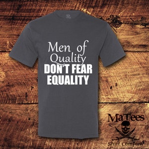 May include: A dark gray t-shirt with the text "Men of Quality Don't Fear Equality" printed in white.