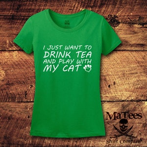 May include: Green t-shirt with white text that reads "I just want to drink tea and play with my cat" with a paw print and heart symbol.