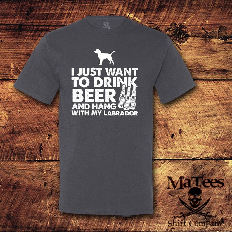 May include: A dark heather gray t-shirt with a white silhouette of a Labrador Retriever and the text "I just want to drink beer and hang with my Labrador".