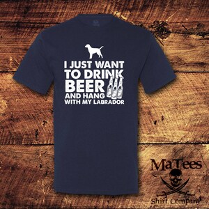 May include: A navy blue t-shirt with a white graphic of a dog and beer bottles. The text on the shirt reads "I just want to drink beer and hang with my labrador".