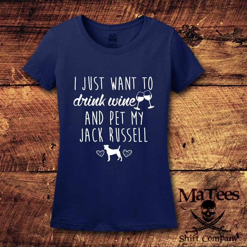 May include: A navy blue t-shirt with the text "I just want to drink wine and pet my Jack Russell" in white. Two wine glasses are shown with a Jack Russell dog illustration.