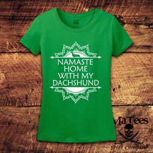 Op de afbeelding: Groen T-shirt met een wit mandala-ontwerp en de tekst "Namaste Home With My Dachshund".