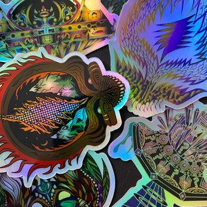 May include: A set of five iridescent holographic stickers featuring abstract designs. The stickers are all different shapes and sizes and have a variety of colours, including purple, blue, green, and gold.