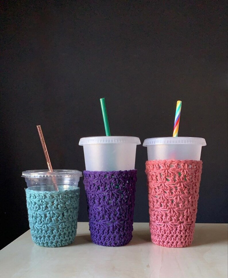 Peut inclure: Trois manchons &agrave; caf&eacute; en crochet de diff&eacute;rentes couleurs&nbsp;: sarcelle, violet et rose. Les manchons sont r&eacute;alis&eacute;s avec un motif de point simple et sont con&ccedil;us pour s&rsquo;adapter aux tasses de taille standard.