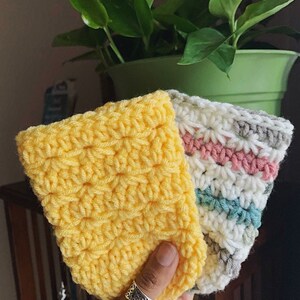 Peut inclure: Trois manchons &agrave; caf&eacute; en crochet de couleur jaune, blanc, gris, rose et bleu. Les manchons sont faits avec un point textur&eacute;.