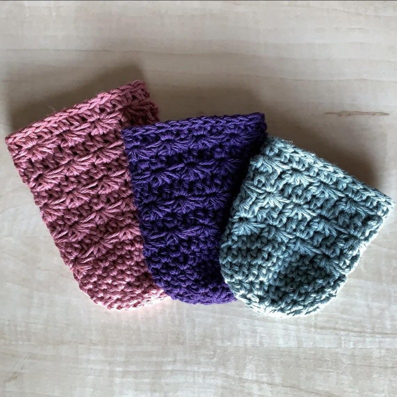 Peut inclure: Trois pochettes en crochet de diff&eacute;rentes couleurs&nbsp;: rose, violet et bleu-vert. Les pochettes sont r&eacute;alis&eacute;es avec un motif de point simple et ont une surface l&eacute;g&egrave;rement textur&eacute;e.
