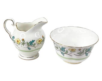 Juego de cremera y azucarero abiertos de porcelana fina toscana vintage. Jarra de leche con diseño floral amarillo verdoso.