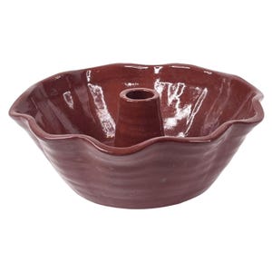 May include: A maroon ceramic bundt pan with a central tube and a wavy rim. The pan has a glossy finish and is designed for baking cakes. The interior and exterior are the same color.