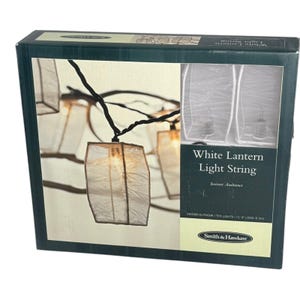 May include: A box featuring a white lantern light string. The string has ten lights and is 11' 6" long. The lanterns are square-shaped and made of a translucent material. The text "White Lantern Light String" is visible on the box.