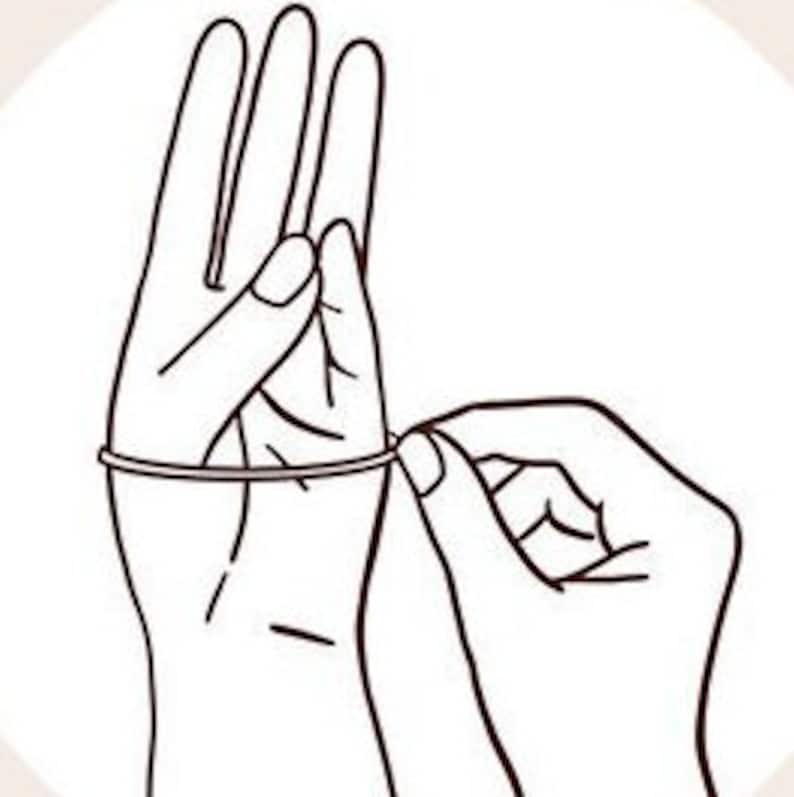 May include: A hand wearing a rubber glove is being pulled on by another hand. The glove is being pulled up the arm.