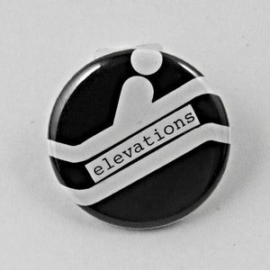 May include: A black and white button with a stylized graphic of a person walking up stairs. The text "elevations" is printed on the button.