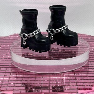 May include: A pair of black platform boots with silver chain accents. The boots have a chunky heel and a rounded toe.