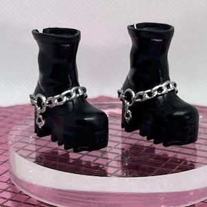 May include: A pair of black platform boots with silver chain accents. The boots have a chunky heel and a rounded toe.