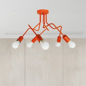 May include: Orange metal ceiling light fixture with six light bulbs. The light fixture has a modern, abstract design.