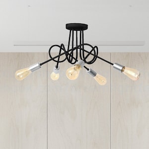 May include: A black ceiling light fixture with five light bulbs. The fixture has a modern, abstract design with curved arms.