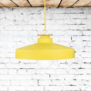 May include: A yellow pendant light fixture with a wooden base hangs from a white ceiling against a white brick wall.