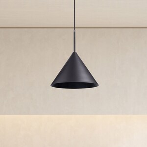 May include: A black pendant light fixture hangs from the ceiling in a modern kitchen. The light fixture has a cone-shaped shade.