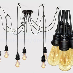 May include: Black pendant light fixture with eight black cords and eight clear glass bulbs. The cords are suspended from a black ceiling plate.
