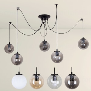 May include: A black ceiling light fixture with six globe-shaped glass shades. The shades are a mix of clear, white, and smoked glass.