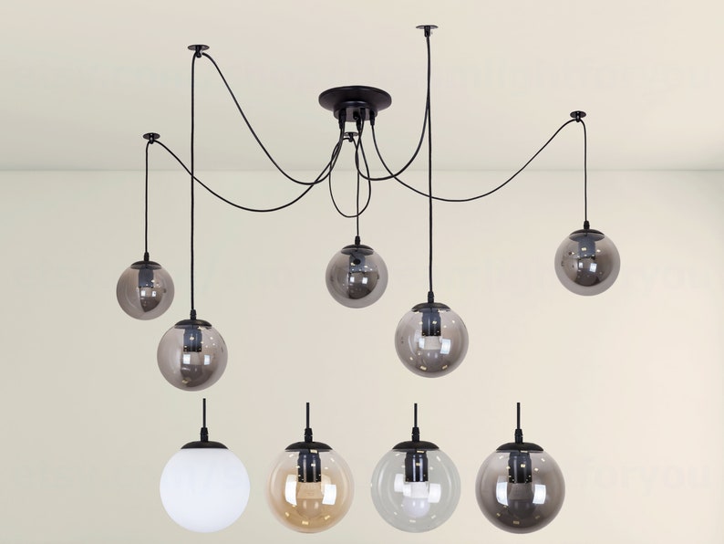 May include: A black ceiling light fixture with six globe-shaped glass shades. The shades are a mix of clear, white, and smoked glass.
