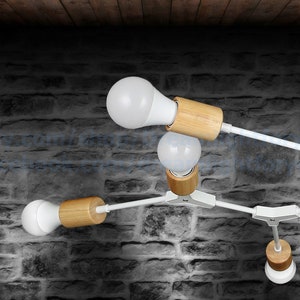 May include: A white ceiling light fixture with multiple arms and wooden accents. The light fixture has five white light bulbs.