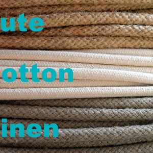 May include: Close-up of three different types of rope: jute, cotton, and linen. The jute rope is brown, the cotton rope is white, and the linen rope is a light brown.