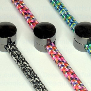 Può includere: Tre terminali per cavi in metallo nero con cavi intrecciati di diversi colori. I cavi sono nero e bianco, rosa e bianco, e blu e verde.