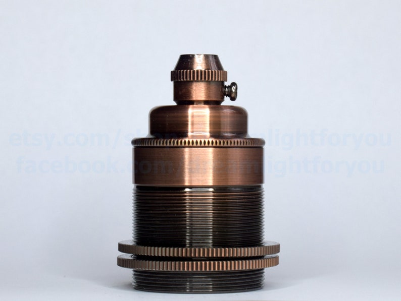 May include: A copper-colored light bulb socket with a threaded base and a small screw on the top.