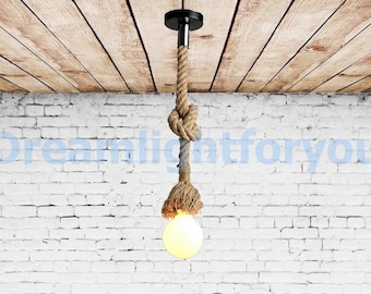 May include: A pendant light fixture featuring a thick, natural-colored jute rope suspended from a black circular ceiling mount. The rope is tied in a decorative knot and holds a single, round, glowing light bulb at its lower end.