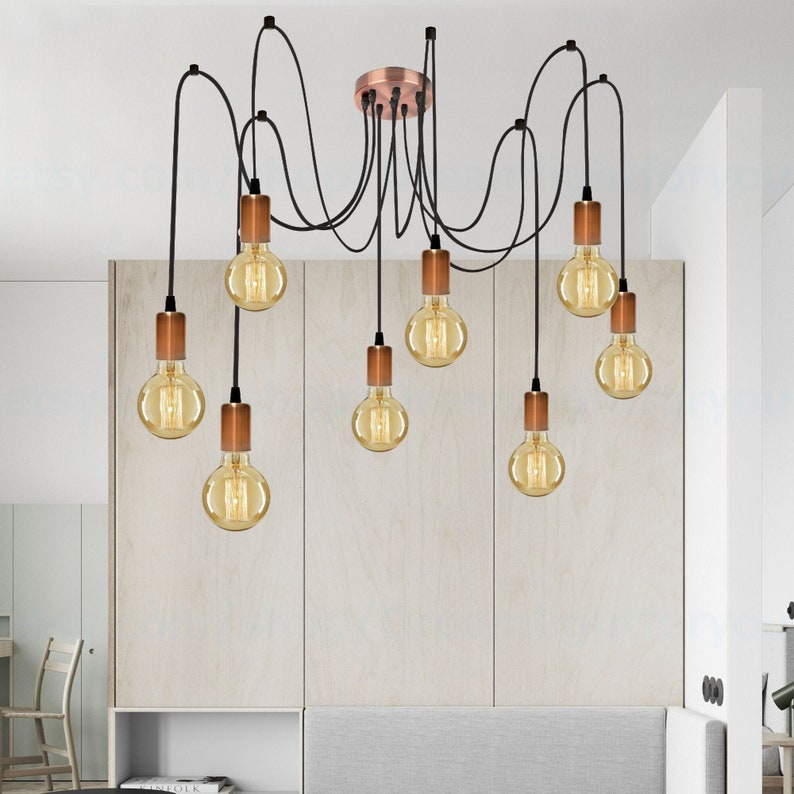 May include: A black and copper 8-light pendant chandelier with exposed wiring and Edison bulb light fixtures.