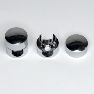 May include: Three chrome-plated metal end caps for a glass shower rod. The end caps are round and have a smooth, polished finish.