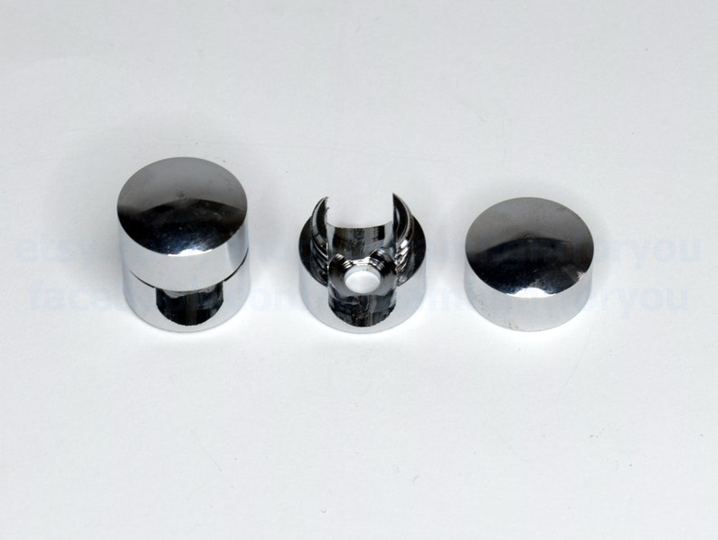 May include: Three chrome-plated metal end caps for a glass shower rod. The end caps are round and have a smooth, polished finish.