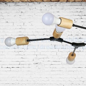 May include: A modern black and wood ceiling light fixture with five light bulbs. The fixture has a geometric design with multiple arms extending from a central point.