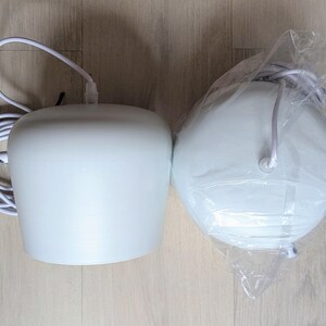 May include: Two white pendant lights, one with a cord and plug, the other in a plastic bag.