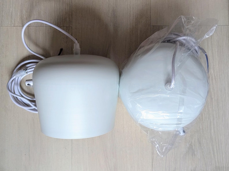 May include: Two white pendant lights, one with a cord and plug, the other in a plastic bag.