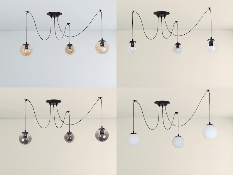 May include: Four black pendant lights with clear and amber glass shades hanging from a ceiling. The lights are connected by black cords and have a unique, modern design.