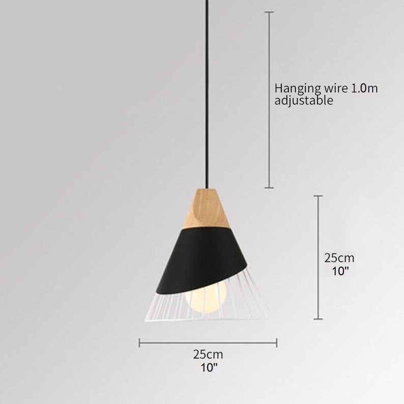 Pu&ograve; includere: Una lampada a sospensione con parte superiore in legno chiaro, sezione centrale conica nera e base a gabbia metallica bianca. L'apparecchio include un cavo di sospensione regolabile da 1,0 m. La lampada misura 25 cm in altezza e 25 cm in larghezza.