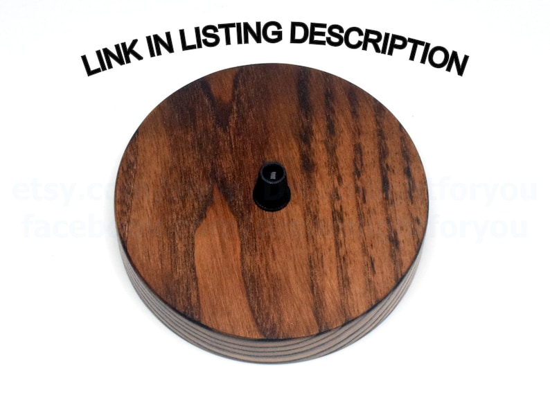 May include: A round wooden ceiling fixture with a dark brown stain. The fixture has a black electrical outlet in the center.